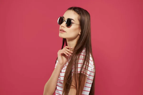 Brunette portant des lunettes rayé débardeur mode été posant fond rose — Photo