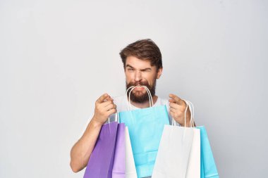 Sakallı yakışıklı adam çanta satıyor.