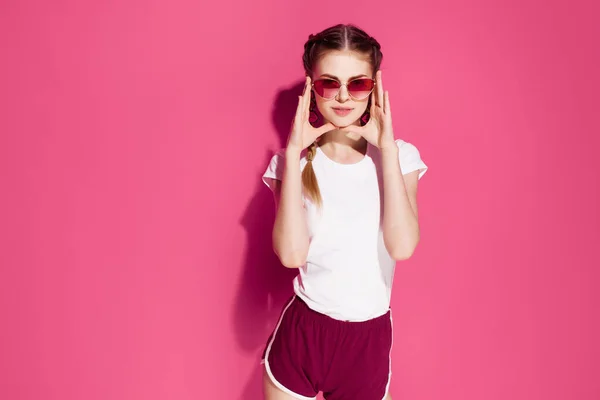 Csinos nő gazdaság copfot nyári divat ruhák pózol rózsaszín háttér — Stock Fotó