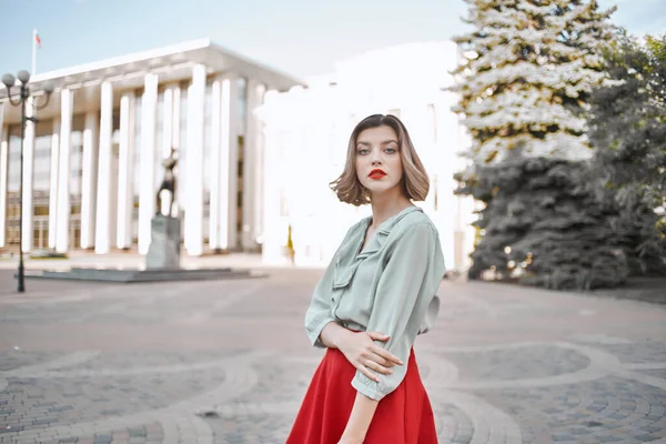 Hübsche Frau im roten Rock, die draußen in der Stadt spaziert — Stockfoto