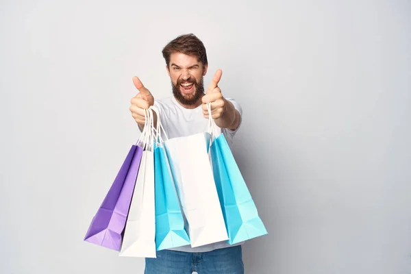 Muž s balíčky v jeho rukou módní nákupní slevy emoce — Stock fotografie