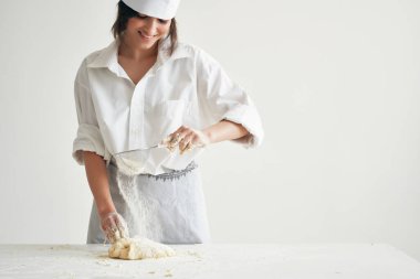 Aşçı üniformalı kadın aşçı mutfak un ürünleri pişiriyor.