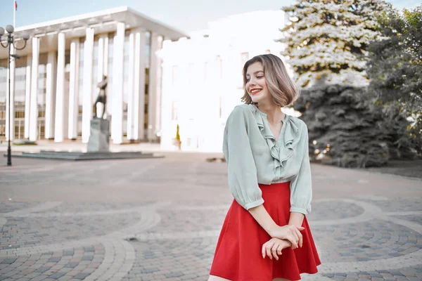 Wesoła blondynka w czerwonej spódnicy na ulicy chodzić styl życia — Zdjęcie stockowe