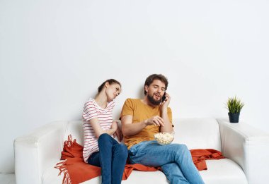 Karı koca kanepede mısır patlatıp film izleyerek eğleniyorlar.