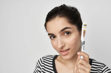 Çizgili tişörtlü esmer elinde diş fırçası temiz diş bakımı