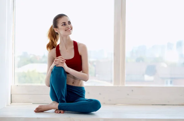 Kvinna gör yoga motion nära fönstret avkoppling — Stockfoto