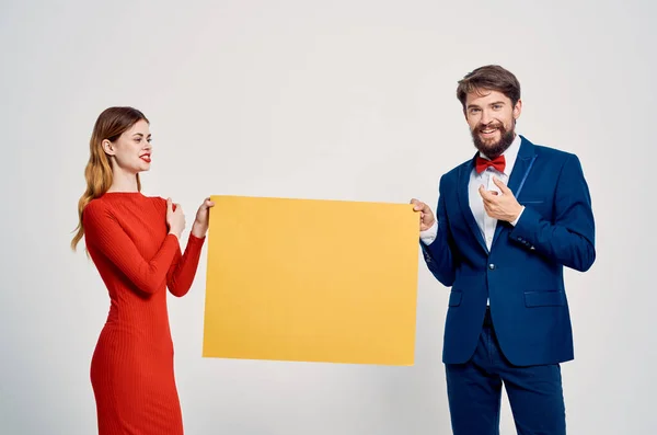 Homme et femme derrière jaune affiche mocap présentation publicitaire — Photo