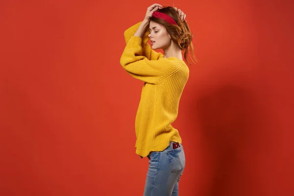 머리에 노란 스웨터를 입고 손으로 포즈를 취하는 예쁜 여성 — 스톡 사진
