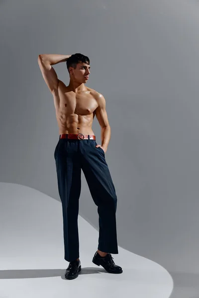 Atleta con un torso bombeado desnudo torso culturista fitness jeans zapatos —  Fotos de Stock