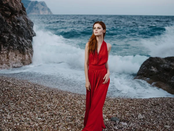 Γυναίκα σε κόκκινο φόρεμα ωκεανούς ακτή θέτοντας σιλουέτα μόδας — Φωτογραφία Αρχείου