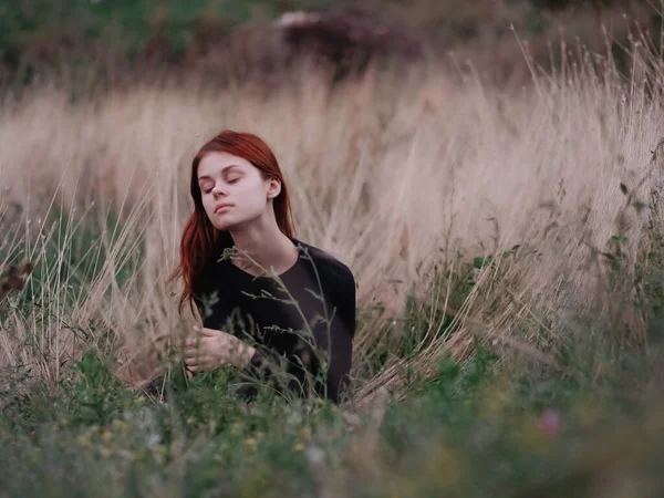 Femme aux cheveux roux se trouve sur l'herbe dans le champ nature air frais été — Photo