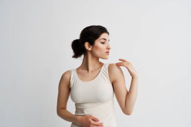 Beyaz tişörtlü kadın yüz bakımının yanında el ele tutuşuyor.