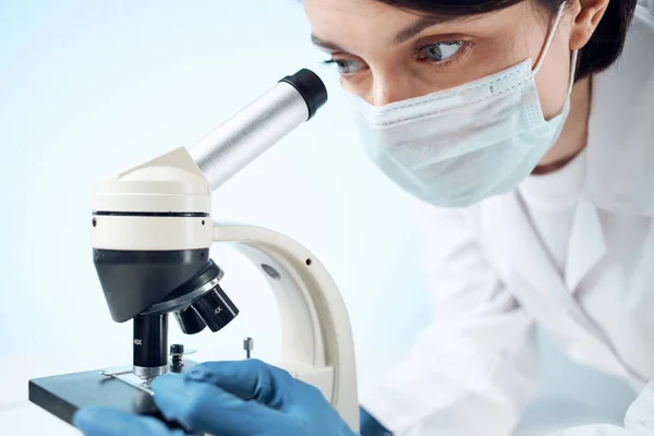 Γυναίκα φορώντας ιατρική μάσκα μικροσκόπιο εργαστήριο τεχνολογίας επαγγελματική — Φωτογραφία Αρχείου