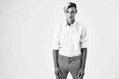 Beyaz gömlekli ve pantolonlu adam şık poz verme stili.