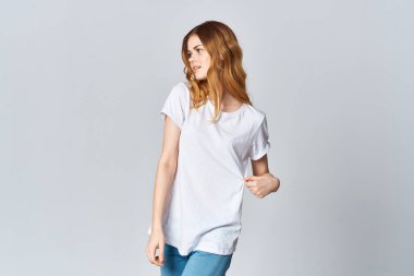 Beyaz tişörtlü kadın moda tasarımı reklamında poz veriyor.