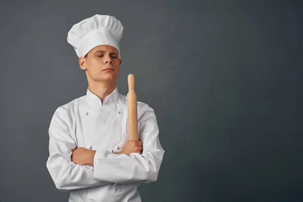 Veselý kuchař v uniformě kuchyňské položky v rukou profesionální restaurace — Stock fotografie