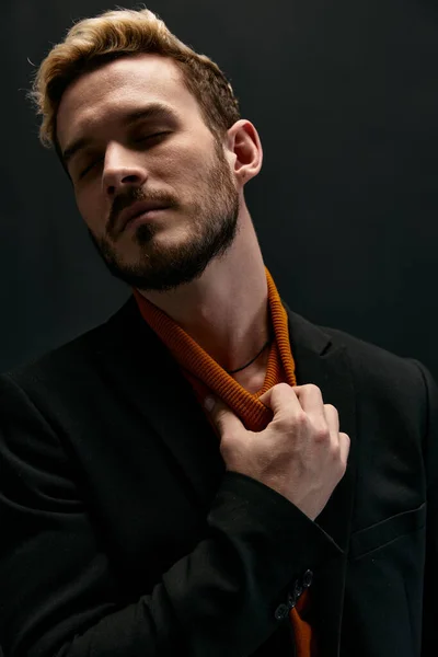 Hombre elegante en traje clásico abrigo suéter naranja fondo negro —  Fotos de Stock