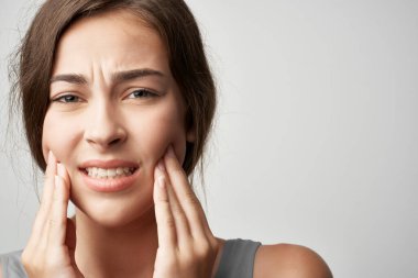 Diş ağrısı çeken bir kadın diş hekimi rahatsızlığı çekiyor.