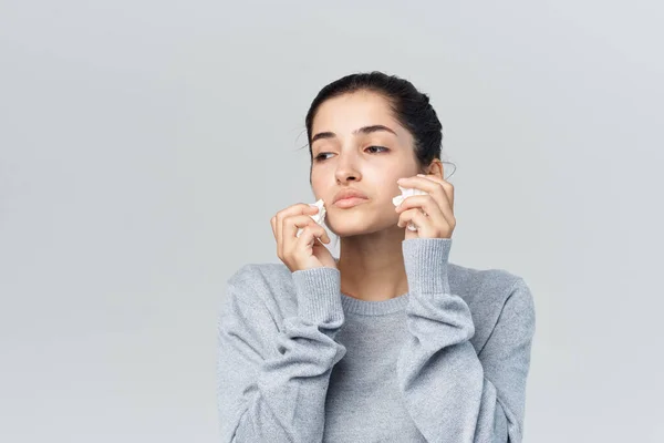Больная женщина вытирает лицо с носовым платком холодного изолированного фона — стоковое фото