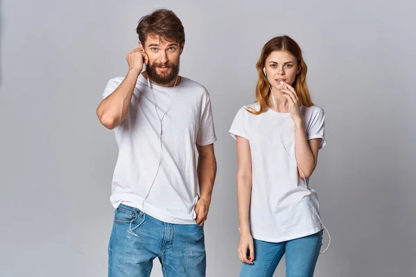 Giovane coppia ascoltare musica in bianco t-shirt divertimento — Foto Stock