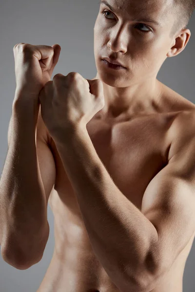 회색 배경에 토 소 복싱을 하고 있는 운동 선수는 근육 모델에 대한 견해가 엇갈렸다 — 스톡 사진