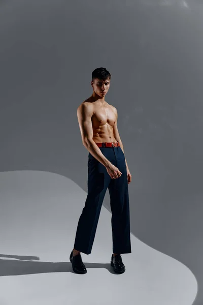 Um homem com um torso bombeado em jeans e botas está em pleno crescimento — Fotografia de Stock