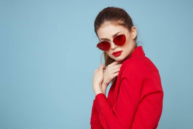 Kırmızı tişörtlü güzel kadın güneş gözlüğü mavi arka plan