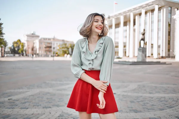 Mujer alegre en falda roja en la plaza al aire libre posando — Foto de Stock