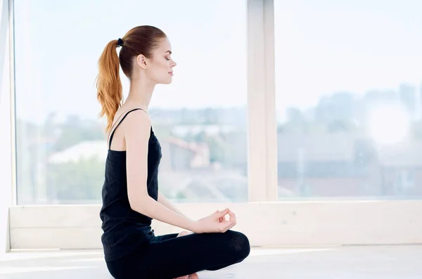 Mujer medita cerca de ventana ejercicio de equilibrio tranquilo — Foto de Stock