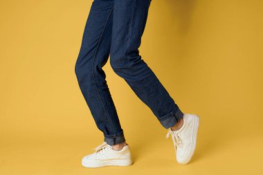 Kadınların beyaz spor ayakkabıları modern tarz sarı arka plan.