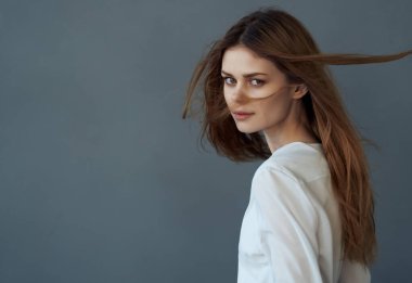 Beyaz elbiseli, güzel saç stili, lüks bir geçmişi olan bir kadın.