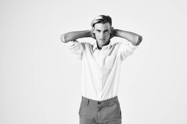 Beyaz gömlekli bir adam elini kafasının arkasında tutarak şık saç stili açık arkaplan