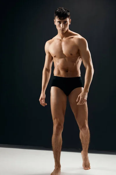 Homem em calcinha preta com bombeado até corpo muscular Estúdio fundo escuro — Fotografia de Stock