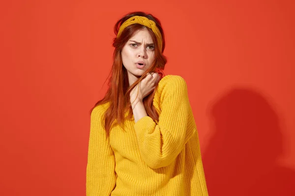 Mulher alegre em suéter amarelo segurando seu estilo hipster estúdio de moda de cabelo — Fotografia de Stock