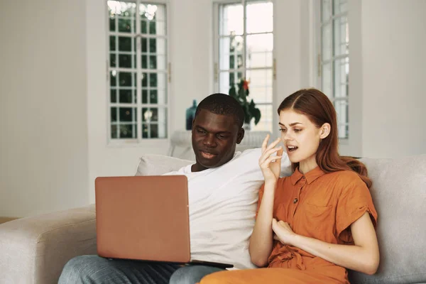 Jeune couple à la maison sur le canapé devant le repos de l'ordinateur portable — Photo