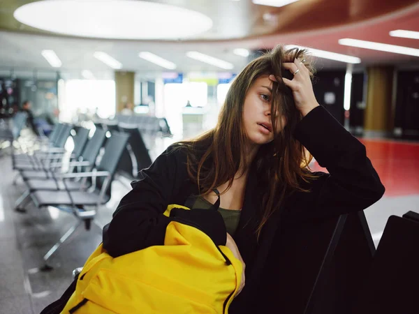 Femme fatiguée tenant sa tête jaune bagages passager de l'aéroport en attente — Photo