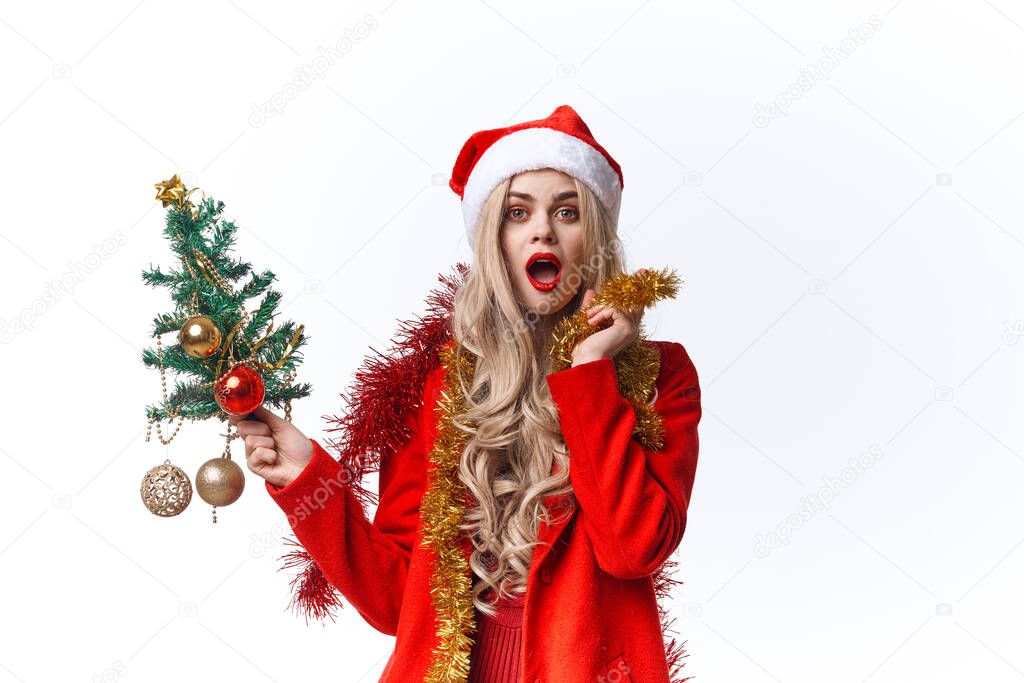 cheerful woman in a Santa costume holding a Christmas tree in her hands