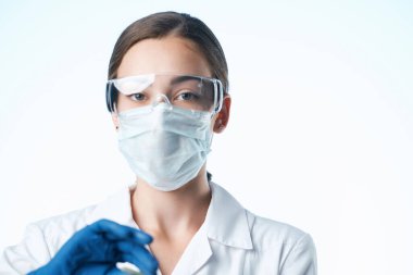 Beyaz önlüklü bir tıbbi maske araştırmasında laboratuvar asistanı...