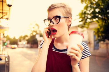 Güzel bir kadın yaz aylarında telefon konuşmaları yapıyor.