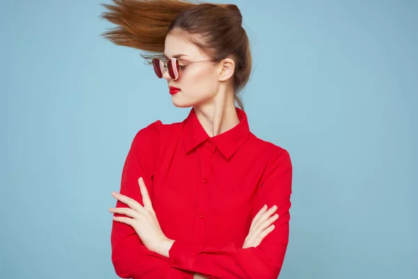 Mooie roodharige vrouw rood shirt mode poseren blauwe achtergrond — Stockfoto