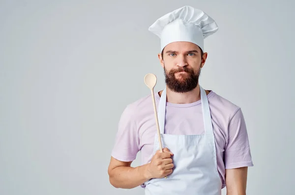 Chef barbudo emocional com um boné na cabeça segura uma colher em suas mãos restaurante Profissional — Fotografia de Stock