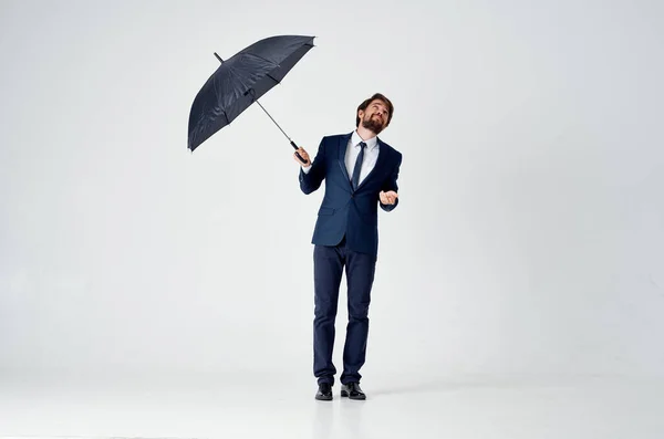 雨宿りの傘を頭に担いでスーツ姿の男が — ストック写真
