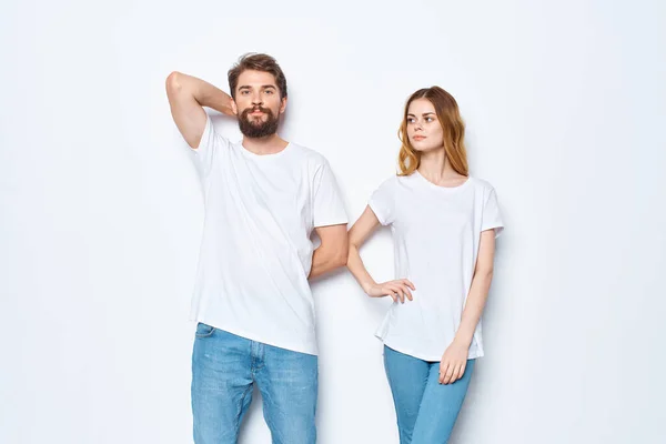 Junges Paar in weißen T-Shirts Kommunikation Kleidung Jeans heller Hintergrund — Stockfoto