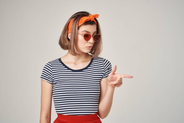 Çizgili tişörtlü, güneş gözlüklü modern moda görünümlü bir kadın.