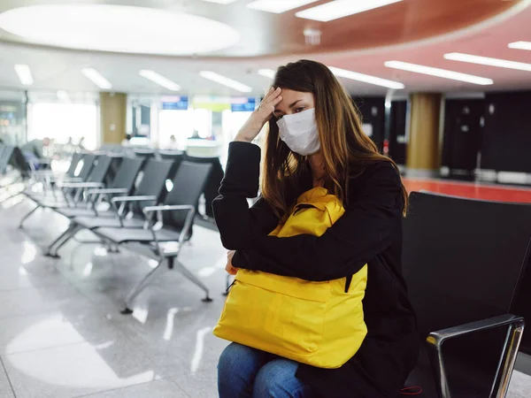 Женщина держит голову в медицинской маске аэропорта ожидание полета задержки — стоковое фото