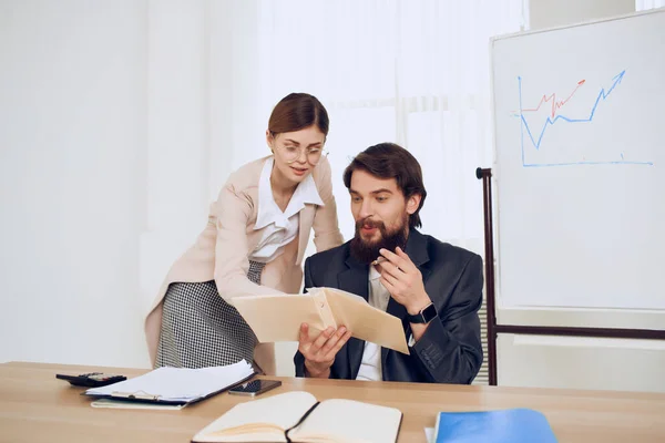 Geschäftsmann sitzt am Schreibtisch neben Sekretärin — Stockfoto