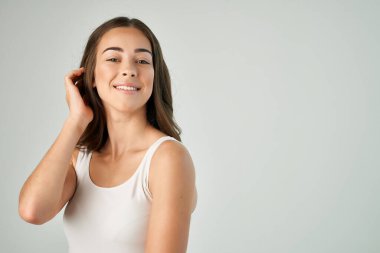 Güzel esmer, beyaz tişörtlü, saç stili, bakımlı, izole bir arka plan.