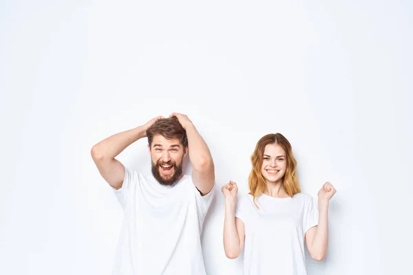 Young couple in white t-shirts communication clothes jeans light background — Stock Photo, Image