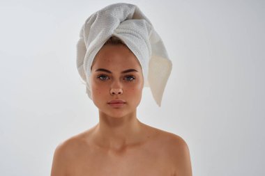 Başında havluyla çıplak omuzlu bir kadın. 