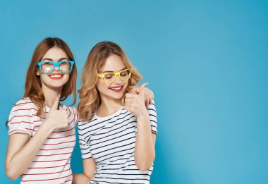 İki kız arkadaş yan yana durur yaz kıyafetleri giyip arkadaş olurlar.